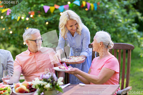 Image of happy family having dinner or summer garden party