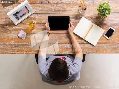 Image of woman with tablet pc and notebook at office table