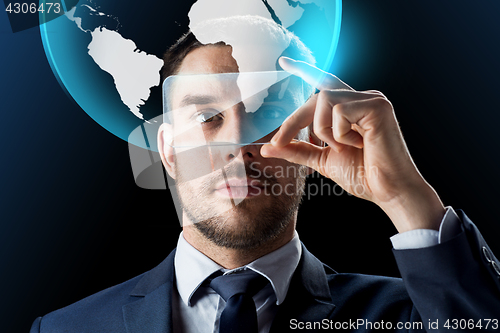 Image of businessman with smartphone and virtual globe