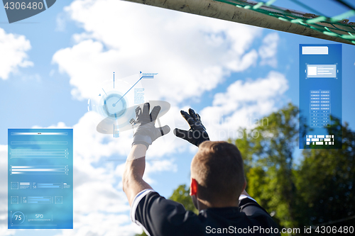 Image of goalkeeper with ball at football goal on field