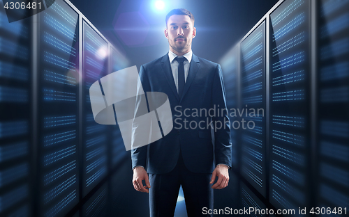 Image of businessman over server room background