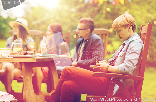 Image of man with smartphone and friends at summer party