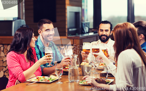 Image of friends dining and drinking beer at restaurant