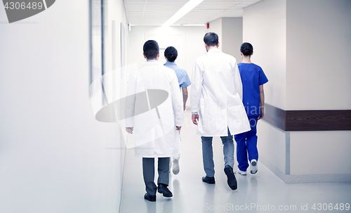 Image of group of medics or doctors walking along hospital