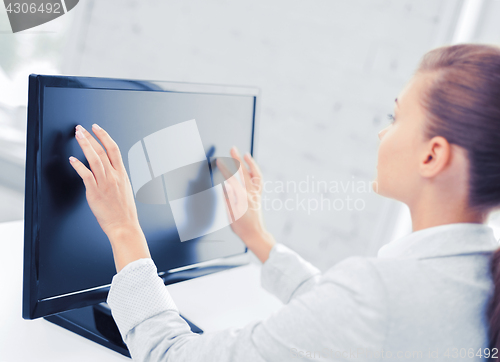 Image of smiling businesswoman with touchscreen in office