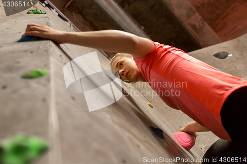 Image of young woman exercising at indoor climbing gym