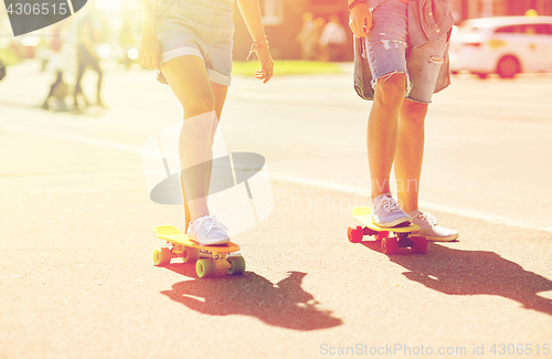 Image of teenage couple riding skateboards on city street
