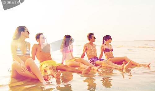 Image of smiling friends in sunglasses on summer beach