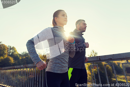 Image of happy couple running outdoors