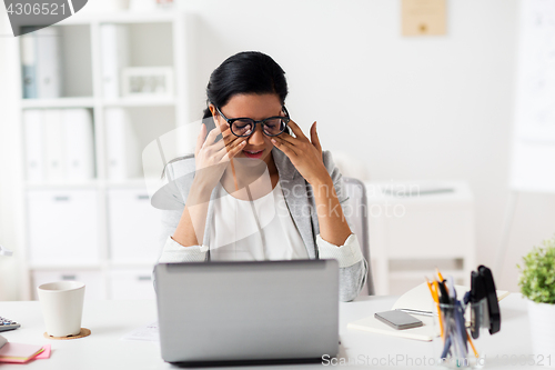 Image of businesswoman rubbing tired eyes at office