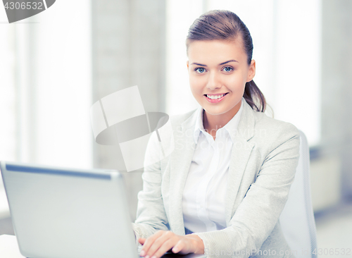 Image of businesswoman with laptop in office