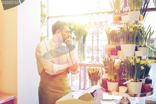 Image of sad florist man or seller at flower shop counter