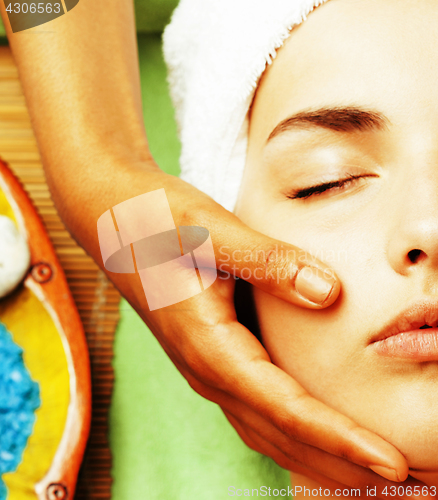 Image of stock photo attractive lady getting spa treatment in salon, close up asian hands on face