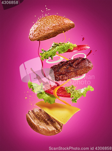 Image of The hamburger with flying ingredients on lilac background