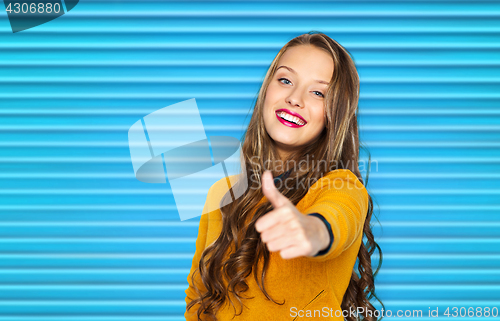 Image of happy young woman or teen girl showing thumbs up