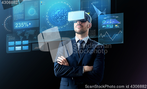 Image of businessman in virtual reality headset over black