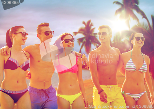 Image of smiling friends in sunglasses on summer beach