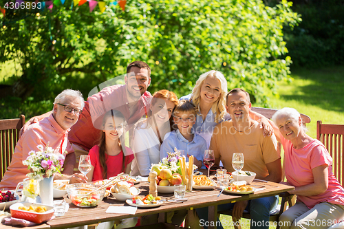 Image of happy family having dinner or summer garden party