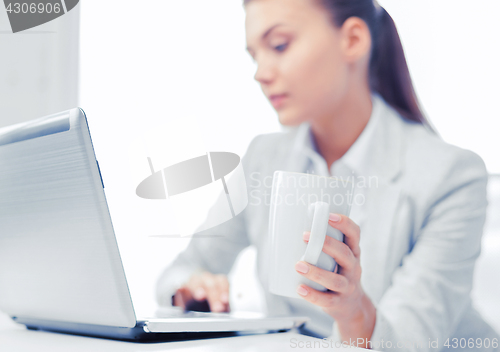 Image of businesswoman with laptop in office