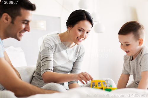 Image of happy family in bed at home or hotel room