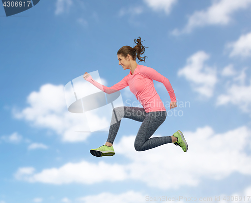 Image of happy smiling sporty young woman jumping in sky