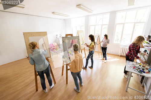 Image of woman artists with brushes painting at art school