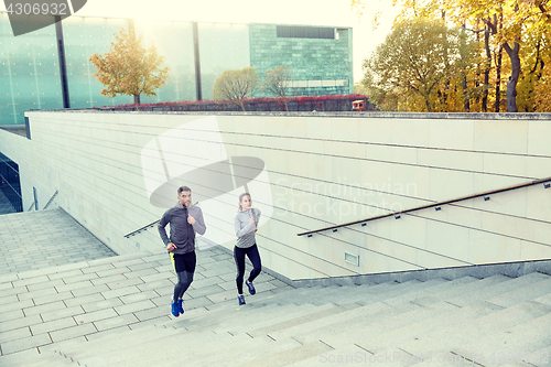 Image of happy couple running upstairs on city stairs