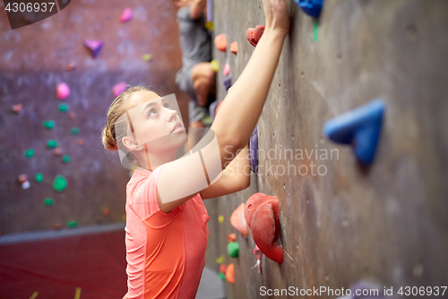 Image of young woman exercising at indoor climbing gym wall