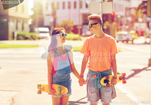 Image of teenage couple with skateboards on city street