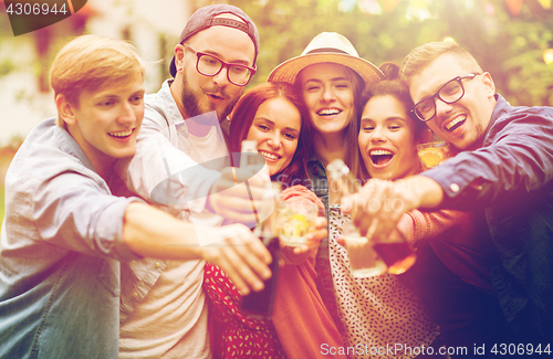 Image of happy friends clinking glasses at summer garden