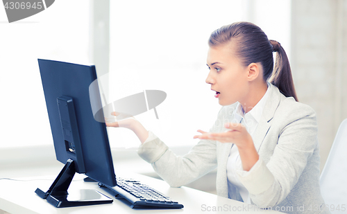 Image of stressed student with computer in office