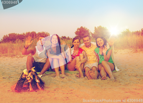 Image of smiling friends in sunglasses on summer beach