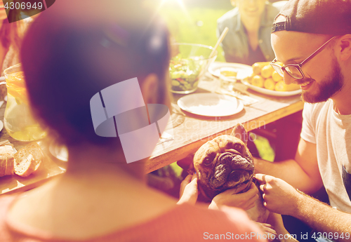 Image of happy friends having dinner at summer garden party