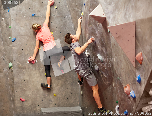 Image of man and woman training at indoor climbing gym wall
