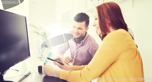 Image of happy creative team with papers at office