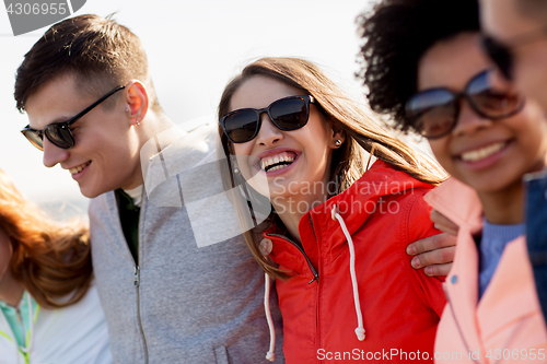 Image of happy teenage friends in shades talking on street