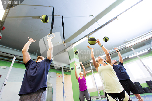 Image of group of people with medicine ball training in gym