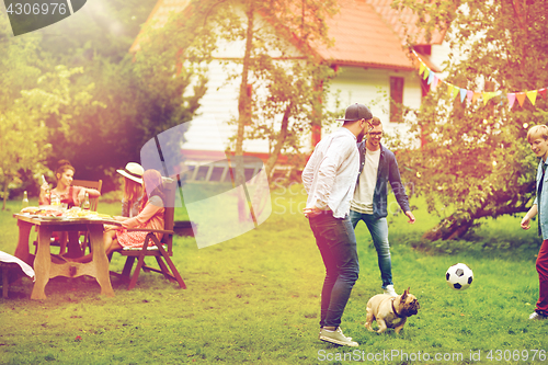 Image of friends playing football with dog at summer garden