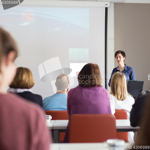 Image of Woman giving presentation in lecture hall at university.