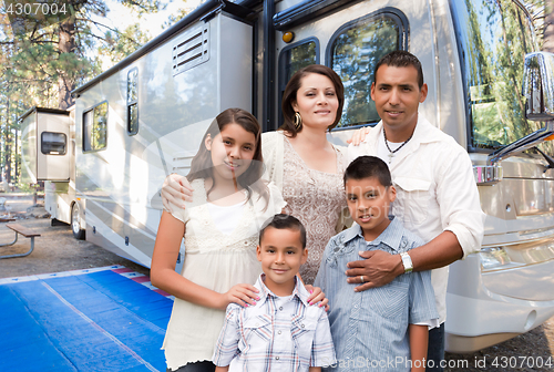 Image of Happy Hispanic Family In Front of Their Beautiful RV At The Camp