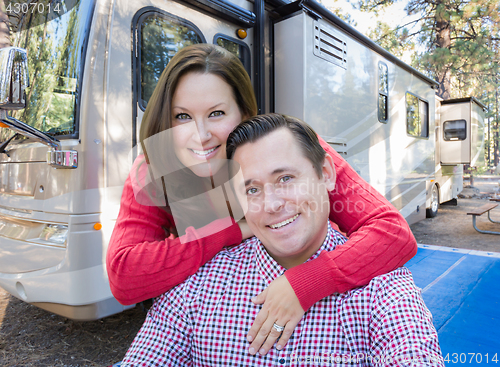 Image of Happy Caucasian Couple In Front of Their Beautiful RV At The Cam