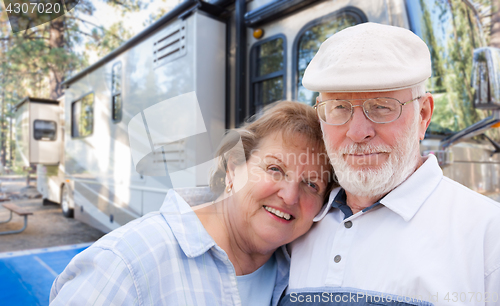 Image of Senior Couple In Front of Their Beautiful RV At The Campground.