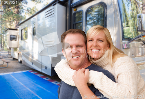 Image of Happy Caucasian Couple In Front of Their Beautiful RV At The Cam