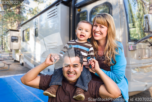 Image of Happy Young Mixed Race Family In Front of Their Beautiful RV At 