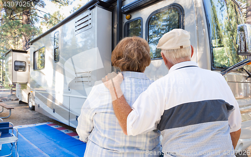 Image of Senior Couple Looking At A Beautiful RV At The Campground.