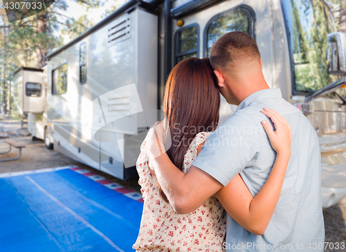 Image of Military Couple Looking At A Beautiful RV At The Campground.