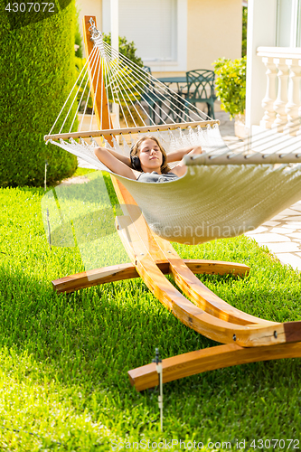 Image of Girl relaxing and listening to music in hammock