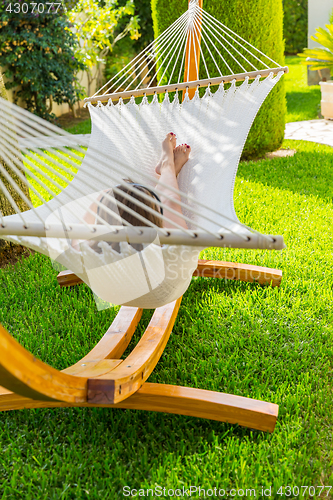 Image of Girl relaxing and listening to music in hammock