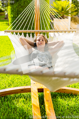 Image of Girl relaxing and listening to music in hammock