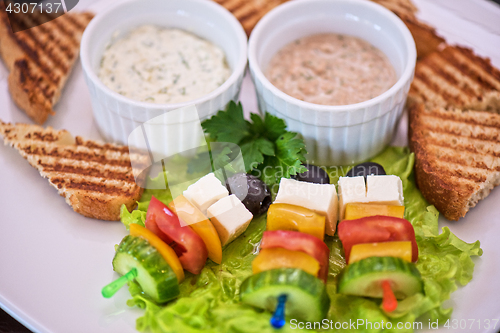 Image of toast with cheese vegetables and olive on the stick